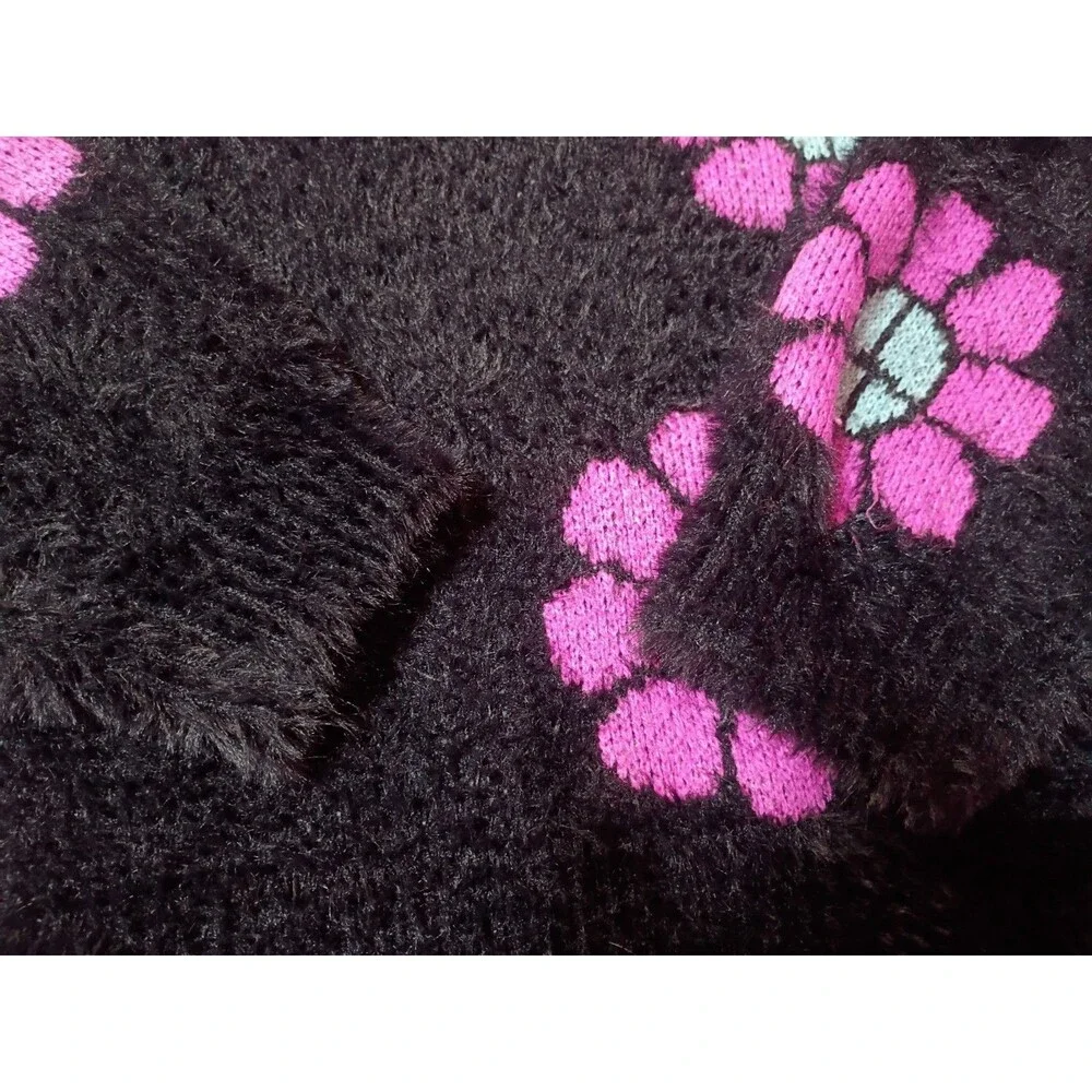 This is a Justice girls' black fuzzy eyelash sweater featuring pink and blue...